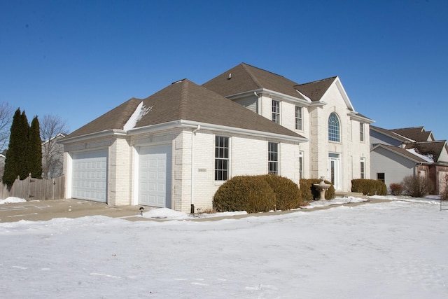 view of snowy exterior featuring a garage