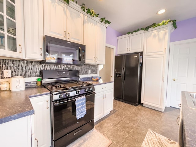 kitchen featuring white cabinets, decorative backsplash, light tile patterned flooring, and black appliances