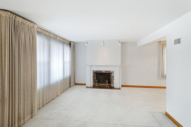 carpeted living room featuring rail lighting and a fireplace