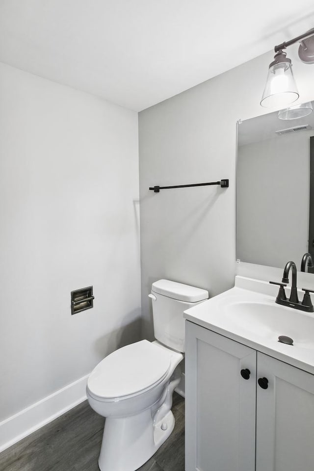 bathroom featuring toilet, wood-type flooring, and vanity