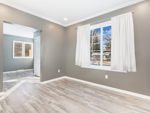 unfurnished room with light hardwood / wood-style floors, plenty of natural light, and ornamental molding