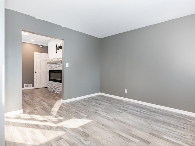 unfurnished room with a fireplace and light hardwood / wood-style flooring