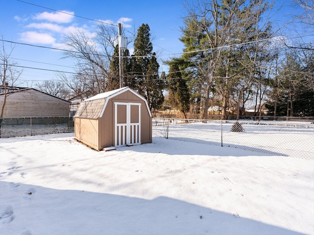 yard covered in snow featuring a storage shed