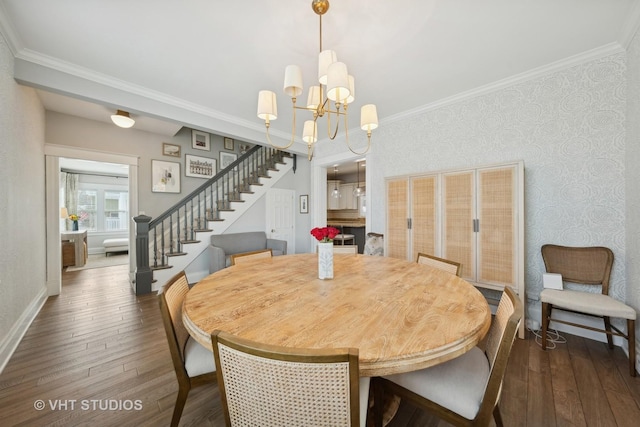 dining area featuring dark wood-type flooring, an inviting chandelier, and crown molding