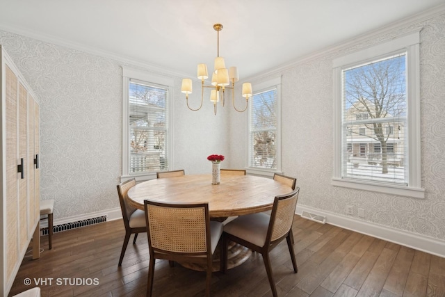 dining area with crown molding, dark hardwood / wood-style floors, and a notable chandelier