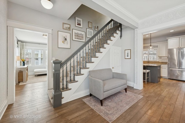 staircase with crown molding and hardwood / wood-style floors