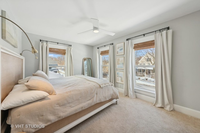 carpeted bedroom with ceiling fan and multiple windows