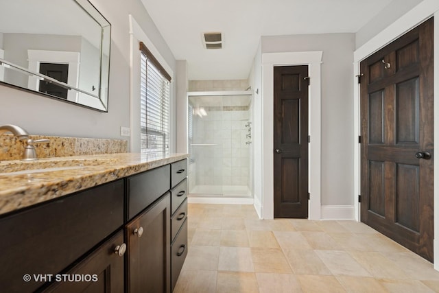 bathroom with vanity and a shower with door