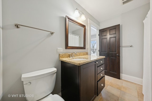 bathroom featuring toilet, tile patterned floors, and vanity