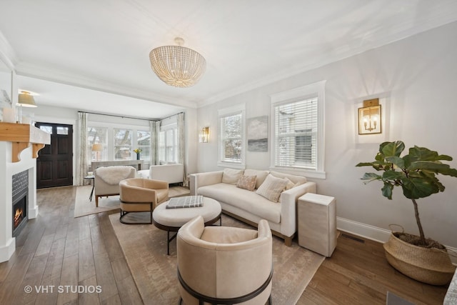 living room with hardwood / wood-style flooring, ornamental molding, and a notable chandelier