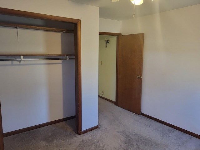 unfurnished bedroom with ceiling fan, light colored carpet, and a closet