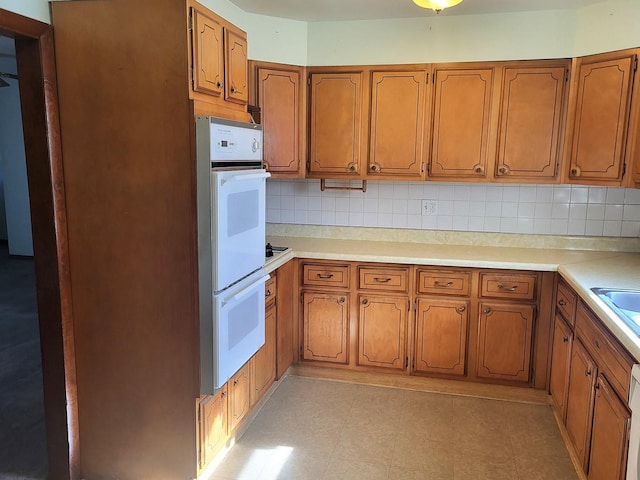 kitchen with sink, backsplash, and white double oven