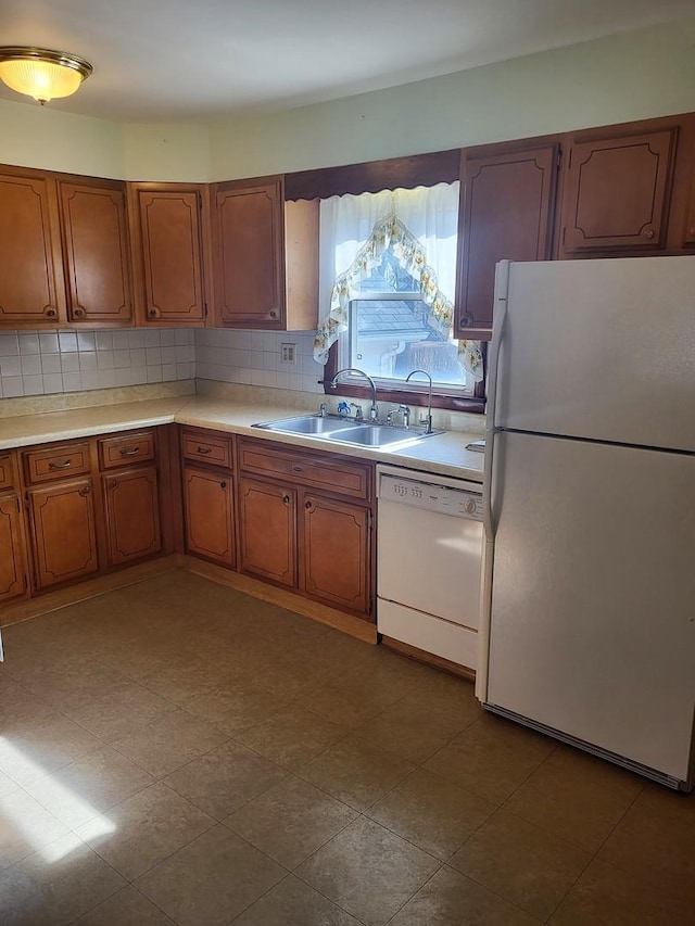 kitchen featuring sink, white appliances, and backsplash