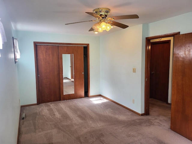 unfurnished bedroom with ceiling fan, light colored carpet, and a closet