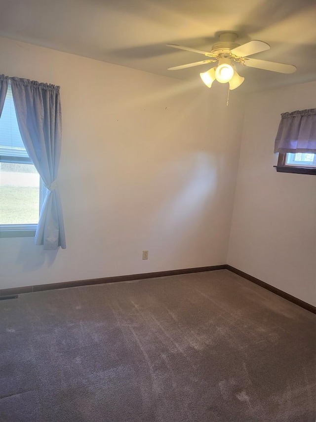 empty room featuring ceiling fan, plenty of natural light, and carpet flooring