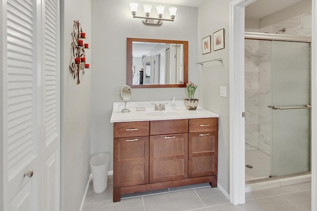 bathroom featuring a shower with shower door, vanity, and tile patterned floors