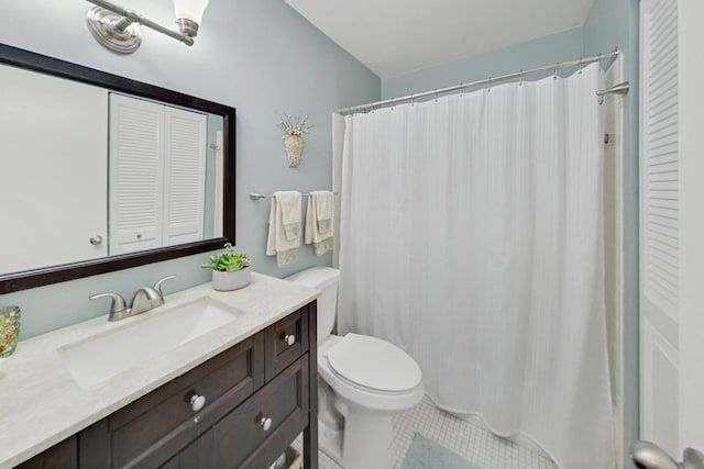 bathroom with toilet, vanity, and tile patterned flooring