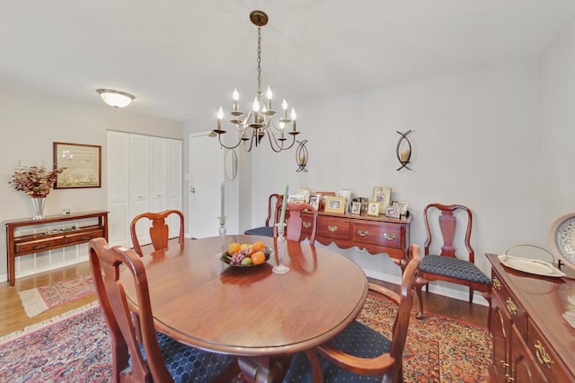 dining area featuring wood-type flooring and a chandelier