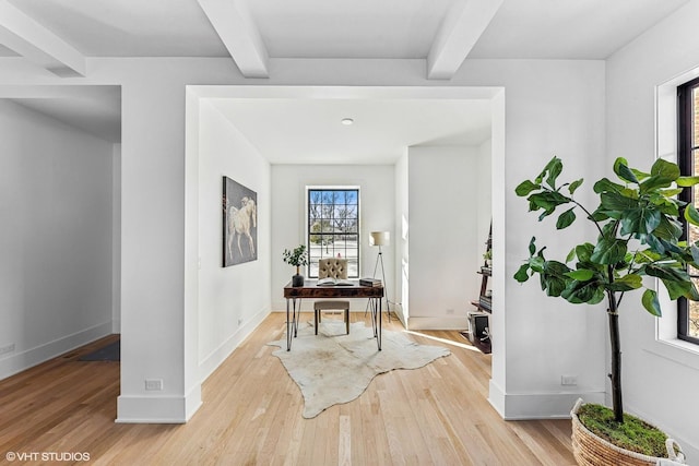 hall featuring a wealth of natural light, light hardwood / wood-style flooring, and beamed ceiling