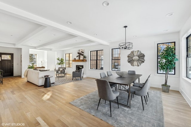 dining area featuring beamed ceiling and light hardwood / wood-style flooring