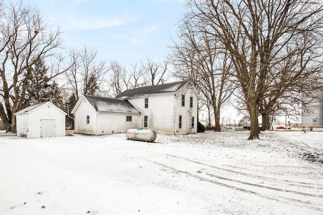 snow covered property featuring a shed