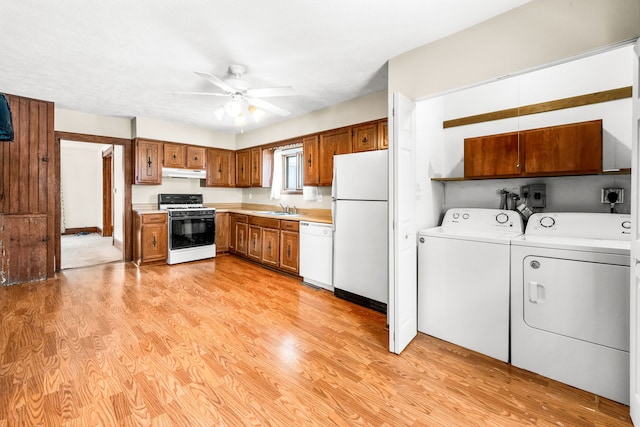 kitchen featuring sink, white appliances, light hardwood / wood-style flooring, ceiling fan, and washing machine and dryer