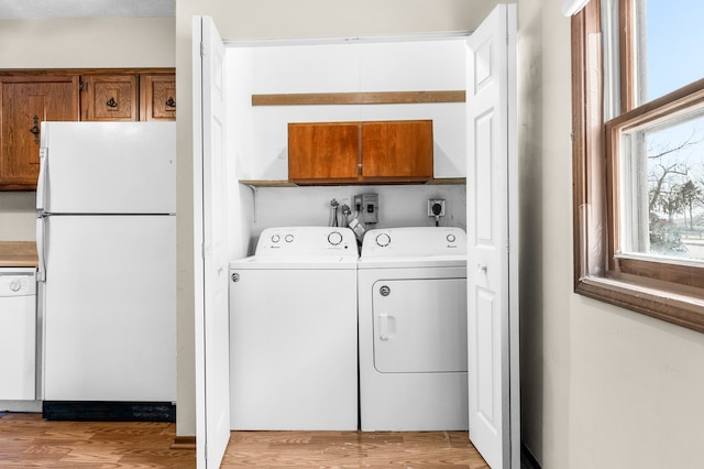 washroom with washer and dryer and light hardwood / wood-style flooring