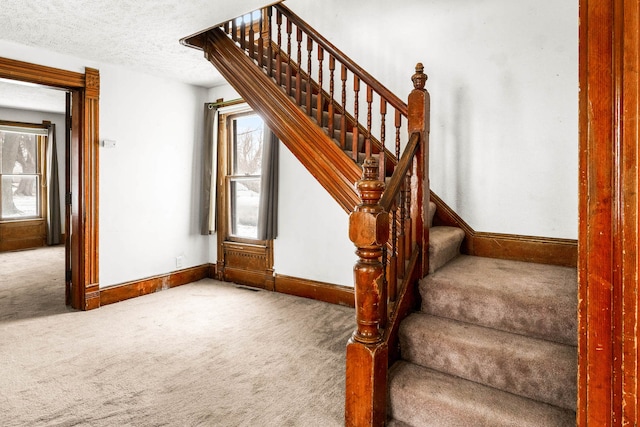 stairs with carpet flooring and a textured ceiling