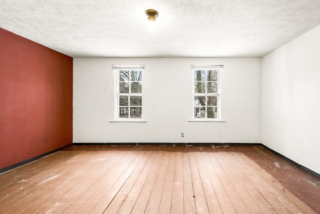 unfurnished room featuring hardwood / wood-style floors and a textured ceiling