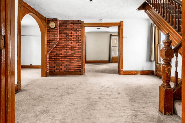 spare room with light carpet and a textured ceiling