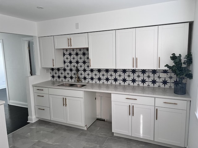 kitchen with sink, white cabinetry, and decorative backsplash