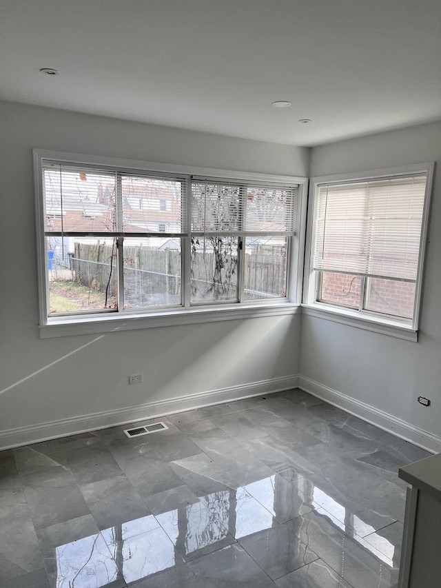 unfurnished room featuring a wealth of natural light