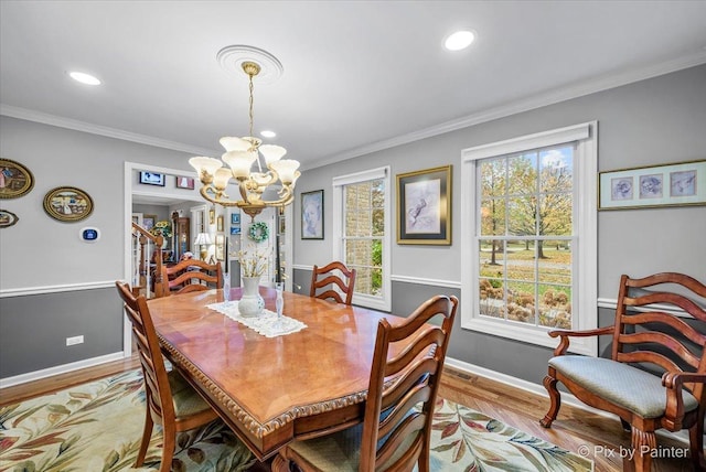 dining room featuring a notable chandelier, light wood-type flooring, and crown molding