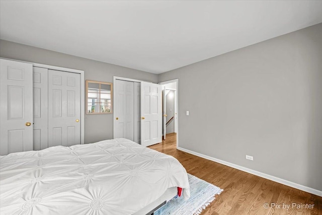 bedroom featuring multiple closets and hardwood / wood-style flooring