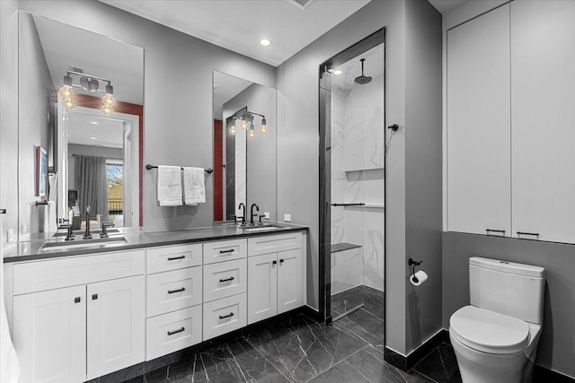 bathroom featuring a tile shower, vanity, and toilet