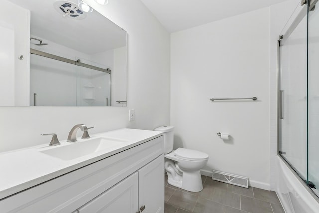 full bathroom featuring tile patterned flooring, vanity, toilet, and bath / shower combo with glass door