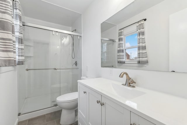 bathroom featuring tile patterned flooring, vanity, toilet, and an enclosed shower