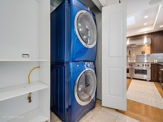 washroom featuring stacked washer / dryer and light tile patterned floors