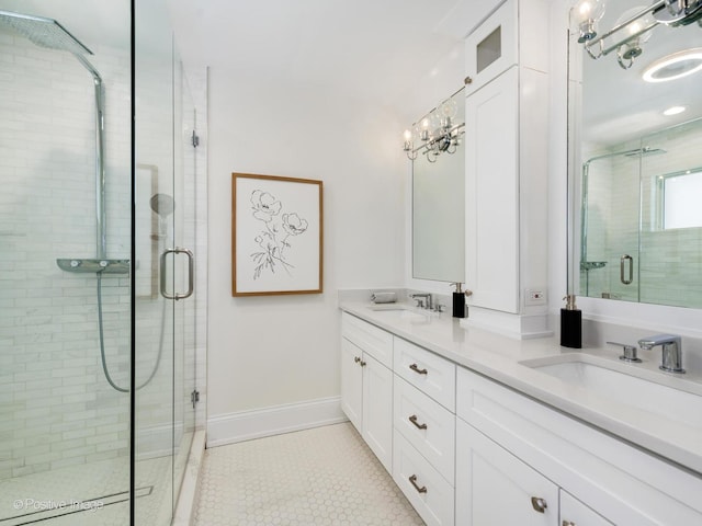 bathroom with an inviting chandelier, vanity, tile patterned floors, and an enclosed shower