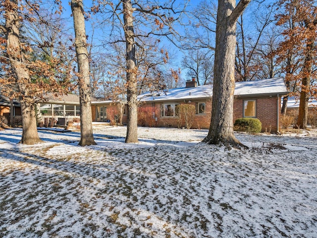 yard layered in snow with a sunroom