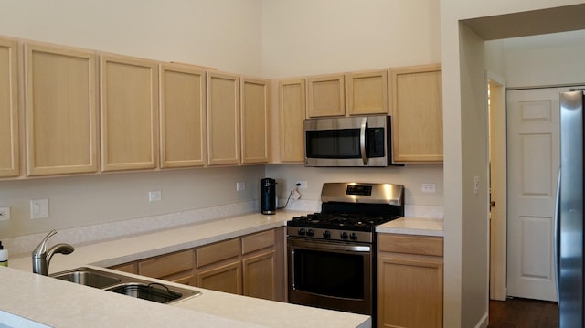 kitchen featuring stainless steel appliances, sink, and light brown cabinets