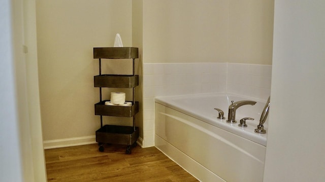 bathroom with wood-type flooring and a bathing tub