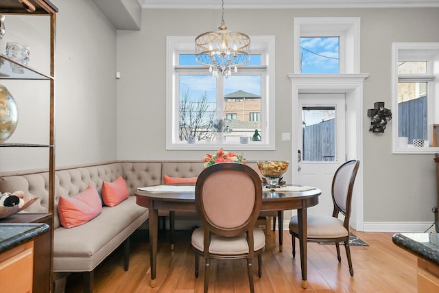 dining room with a notable chandelier, plenty of natural light, and hardwood / wood-style flooring