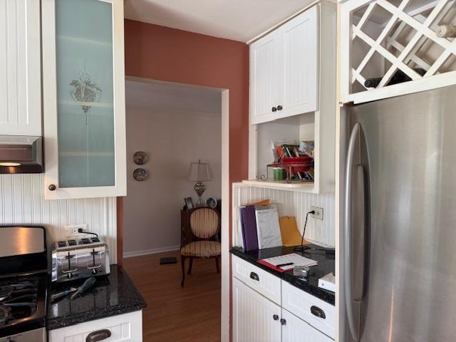 kitchen featuring stainless steel fridge, white cabinetry, and hardwood / wood-style floors