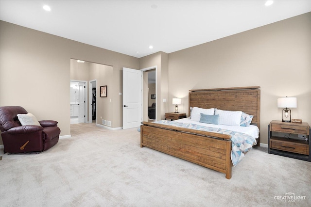 bedroom featuring light carpet and connected bathroom