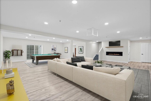 living room with pool table and light hardwood / wood-style flooring