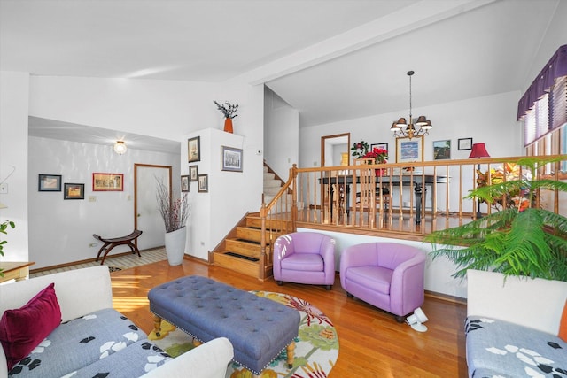 living room with hardwood / wood-style flooring, lofted ceiling, and a chandelier