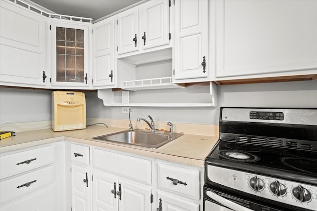 kitchen with sink, stainless steel range with electric cooktop, and white cabinets