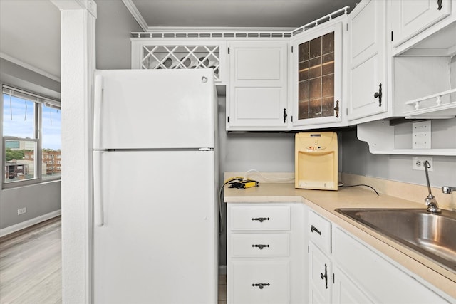 kitchen with white cabinets, white refrigerator, and ornamental molding