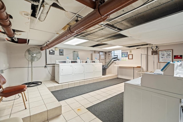 clothes washing area with washer and clothes dryer and light tile patterned floors